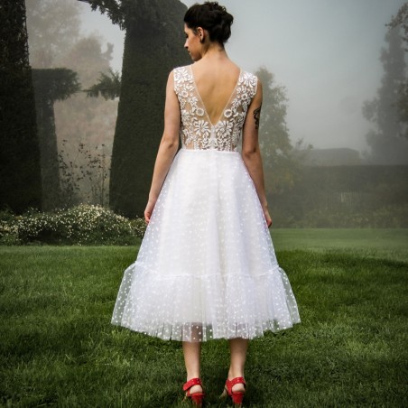 Back view of the dress, showing intricate hand-stitched embroidery and elegant silhouette.
