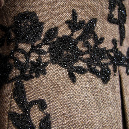 Luxurious black evening jacket with short sleeves and subtle sparkle, accented with pearls and beads.