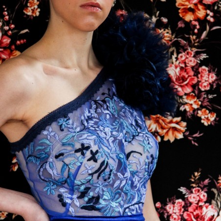 Broderie à la main sur le tissu de velours, montrant la qualité artisanale.