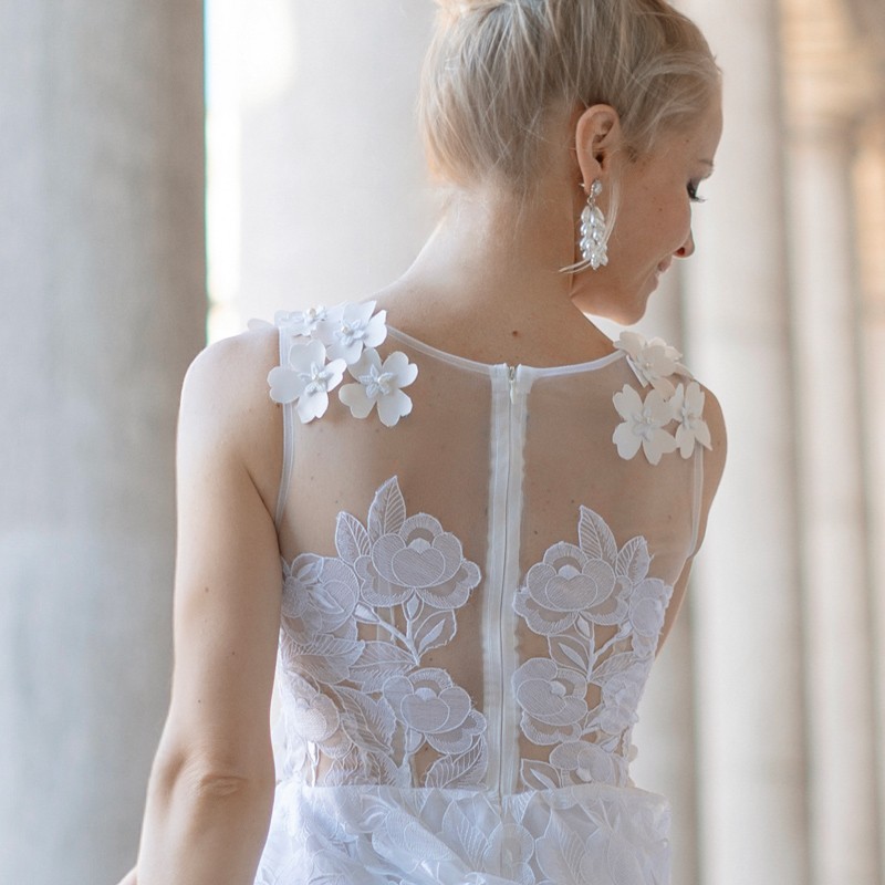 Macro shot of lace fabric with pearl and flower embellishments – highlighting texture and delicate handmade details.