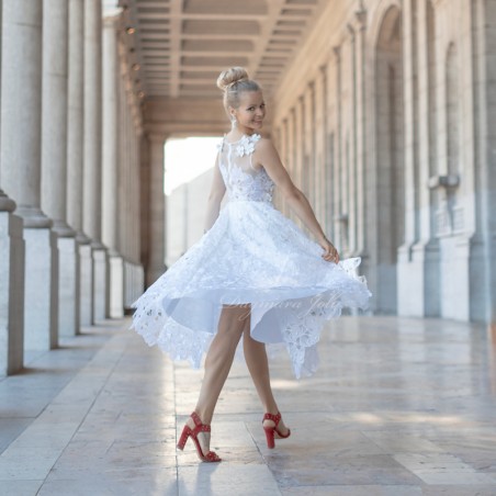 Bride tournant dans une robe de mariée midi en dentelle, montrant l’élégance et la fluidité du tissu.