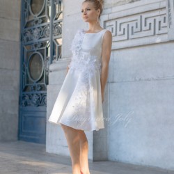 Modèle portant une robe de mariée courte blanche sans manches, ornée de fleurs délicates