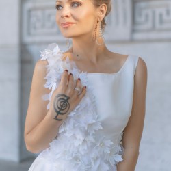 Modèle portant une robe de mariée courte, ornée de fleurs, vue de face, confectionnée sur mesure en France.