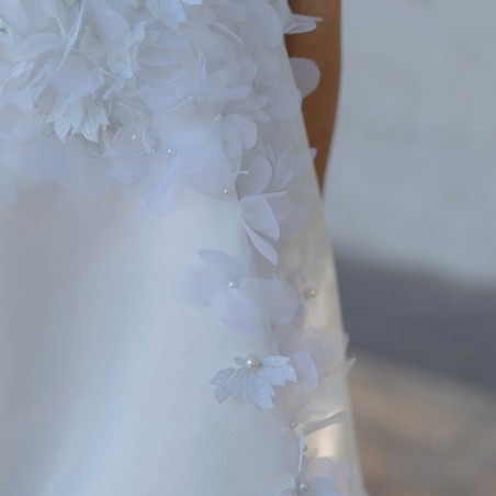 Zoom sur les détails floraux et la texture légère de la robe de mariée courte sur mesure, fabriquée en France.