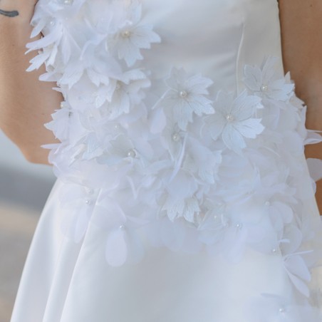 Zoom sur les détails floraux et la texture légère de la robe de mariée courte sur mesure, fabriquée en France.
