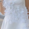 Zoom sur les détails floraux et la texture légère de la robe de mariée courte sur mesure, fabriquée en France.
