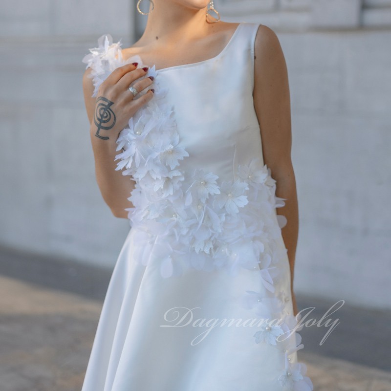 Front profile of a modern short wedding dress, white with hand-sewn flowers, tailored in France.