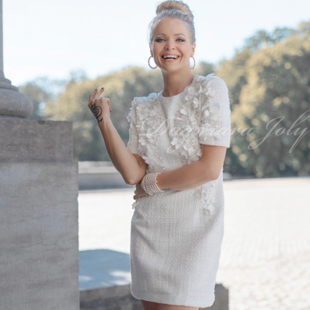 Robe de mariée courte en tweed vue de face, ornée de fleurs et perles.