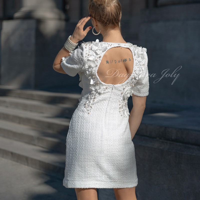 Dos ouvert d'une robe de mariée courte en tweed, avec détails perlés faits main.