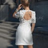 Dos ouvert d'une robe de mariée courte en tweed, avec détails perlés faits main.