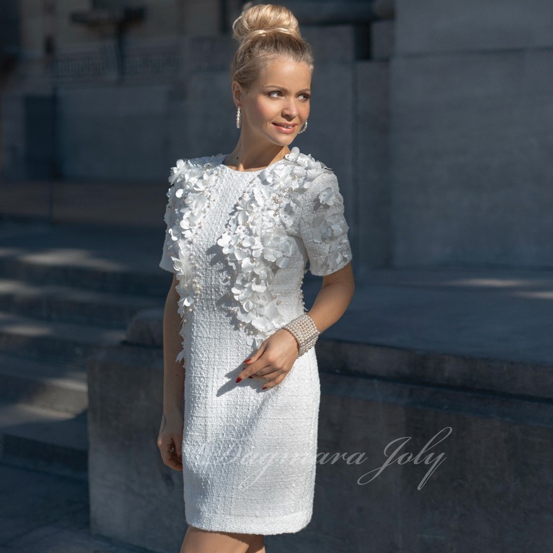Zoomed-in detail of floral and pearl embellishments on a short tweed wedding dress
