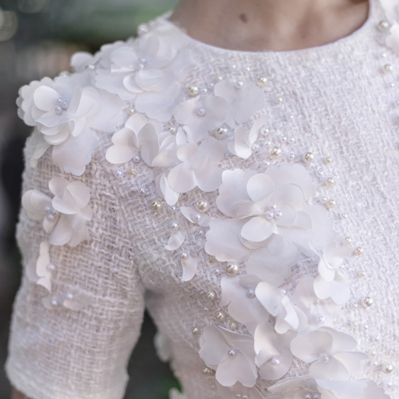 Gros plan sur la texture du tweed brillant de la robe de mariée