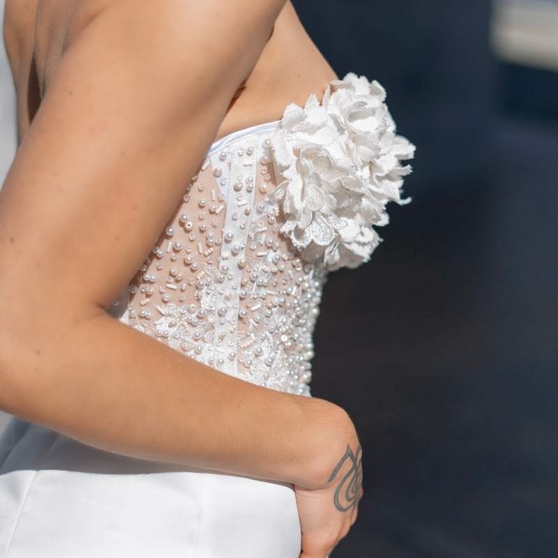 Détail des perles, cristaux et fleurs cousus à la main sur le bustier de la robe