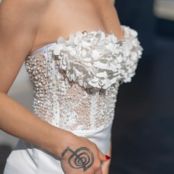 Détail des perles, cristaux et fleurs cousus à la main sur le bustier de la robe