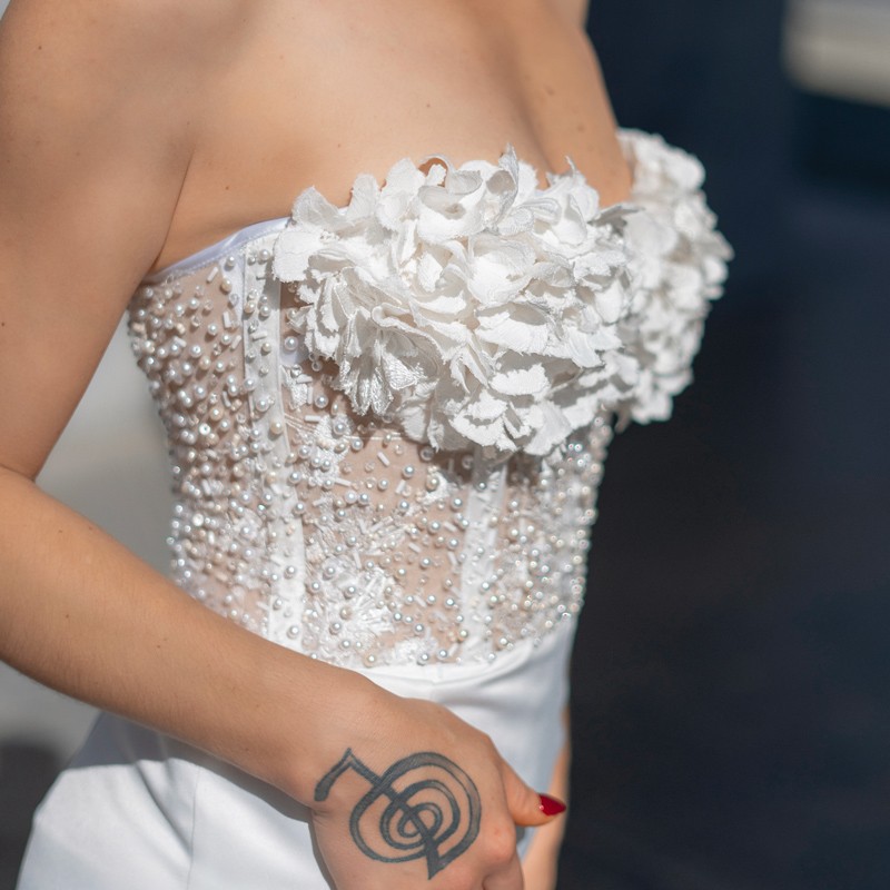 Détail des perles, cristaux et fleurs cousus à la main sur le bustier de la robe