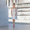 Mannequin portant une robe de mariée courte bustier, faite main en France avec ornements floraux
