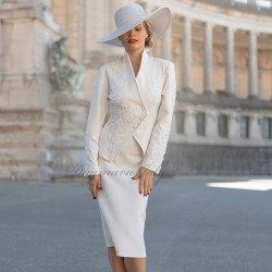 Vue de face du tailleur jupe de mariage, montrant la coupe élégante et les ornements en dentelle.