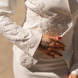 Gros plan sur les ornements faits main et la dentelle délicate du tailleur.