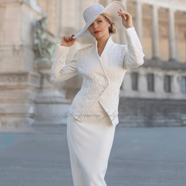 Vue de face du tailleur jupe de mariage, montrant la coupe élégante et les ornements en dentelle.