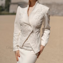 Vue de face du tailleur jupe de mariage, montrant la coupe élégante et les ornements en dentelle.